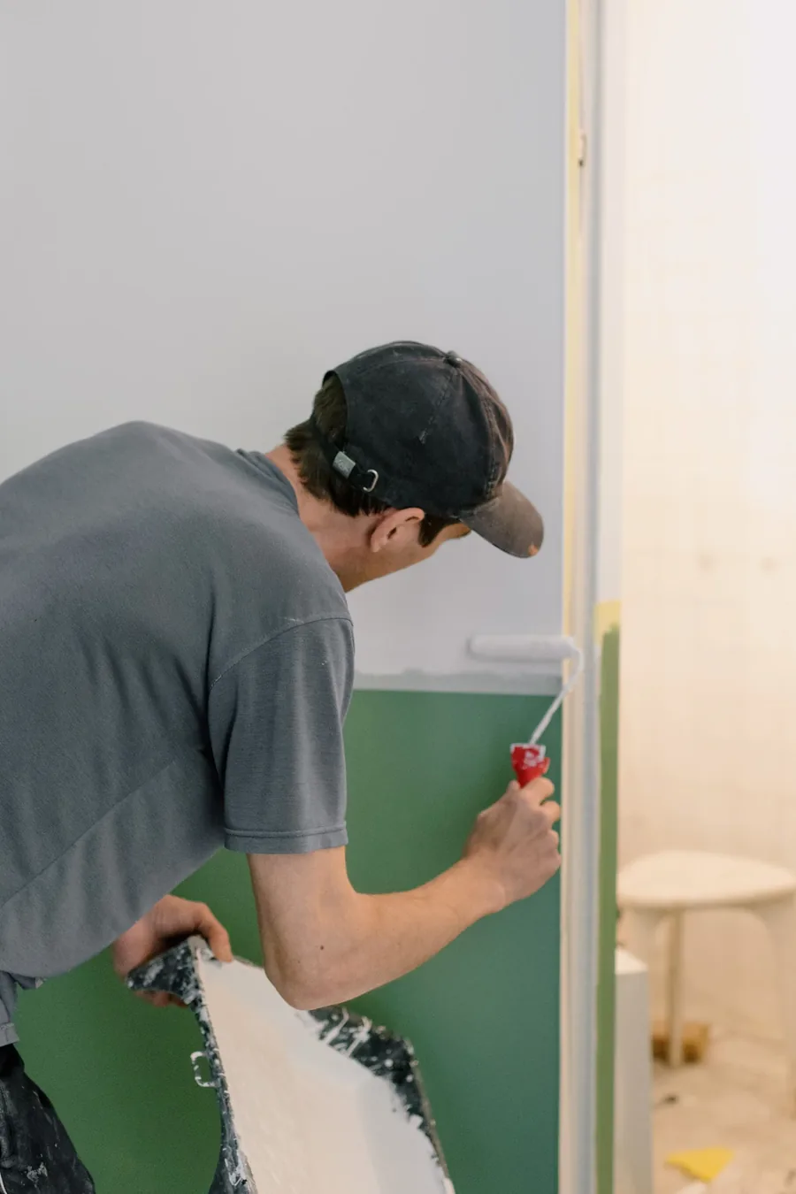 Maler streicht eine Wand mit der Rolle